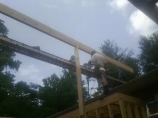Carpenter setting a ridge beam over a new addition frame — Ice Dam Removal by Roofing Brothers in Montpelier